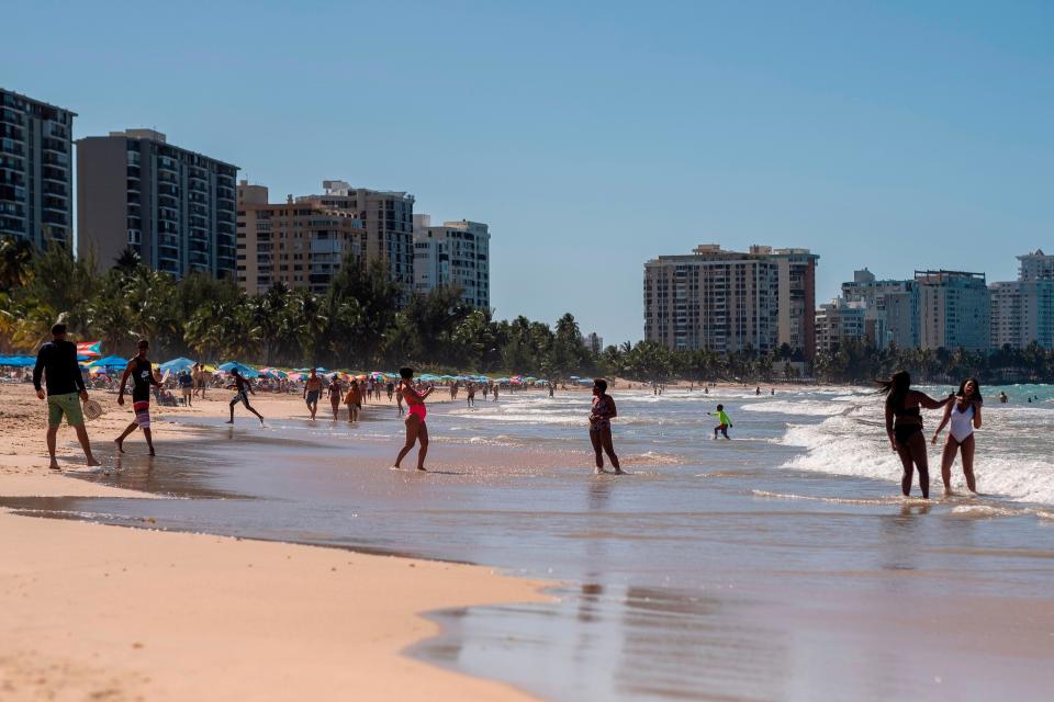 People are seen on the beach in San Juan, Puerto Rico, on March 15, 2020.