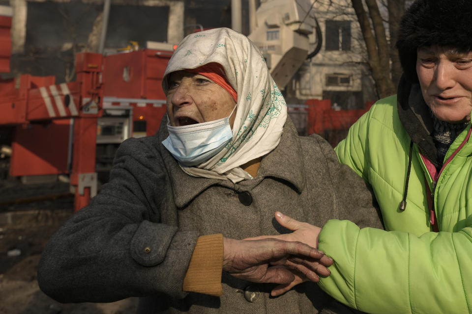 Women cry outside a destroyed apartment building after a bombing in a residential area in Kyiv, Ukraine, Tuesday, March 15, 2022. Russia's offensive in Ukraine has edged closer to central Kyiv with a series of strikes hitting a residential neighborhood as the leaders of three European Union member countries planned a visit to Ukraine's embattled capital. (AP Photo/Vadim Ghirda)