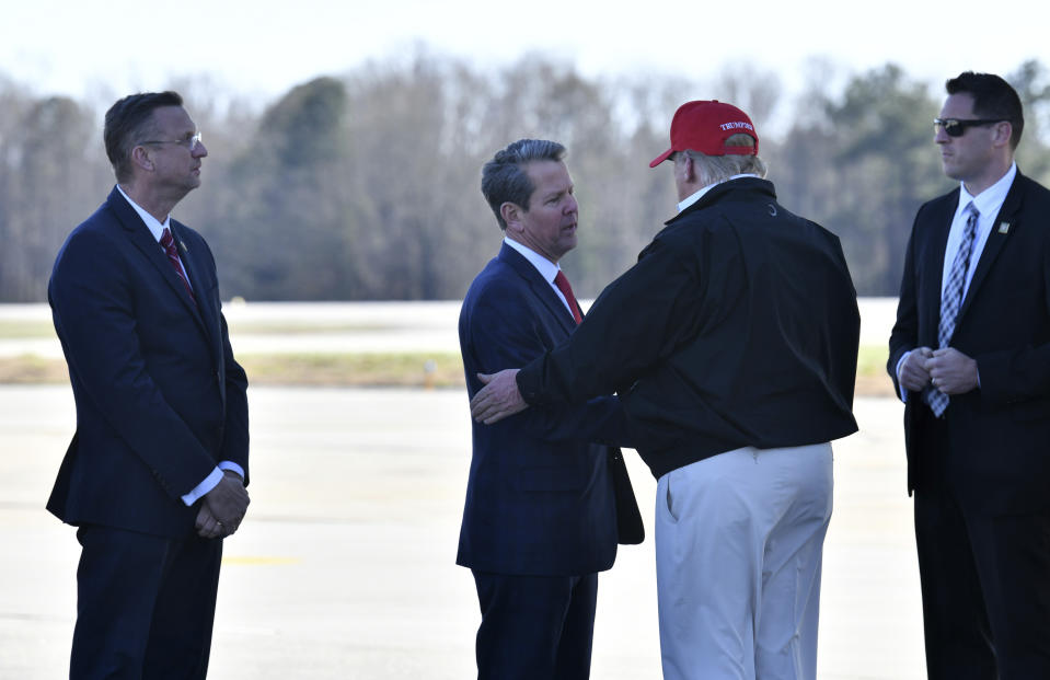 President Donald Trump is greeted by Gov. Brian Kemp at Dobbins Air Reserve Base after the president's trip to tornado-ravaged Tennessee on Friday, March 6, 2020. President Donald Trump visited the headquarters of the Centers for Disease Control and Prevention in Atlanta on Friday after all, after initially scrapping the trip over concerns that a staffer at the agency had contracted the coronavirus. (Hyosub Shin/Atlanta Journal-Constitution via AP)