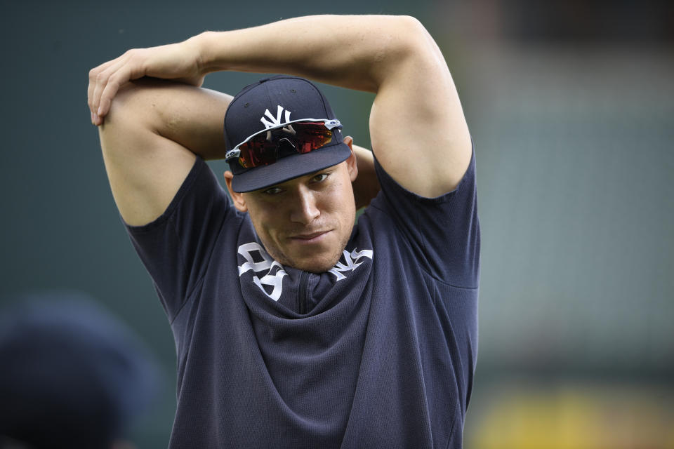 FILE - In this May 20, 2019, file photo, New York Yankees' Aaron Judge stretches on the field before a baseball game against the Baltimore Orioles, in Baltimore. Yankees general manager Brian Cashman is optimistic Aaron Judge, James Paxton, Aaron Hicks and Giancarlo Stanton will be ready to play in time for New York's rescheduled opener at World Series champion Washington on July 23. (AP Photo/Nick Wass, File)