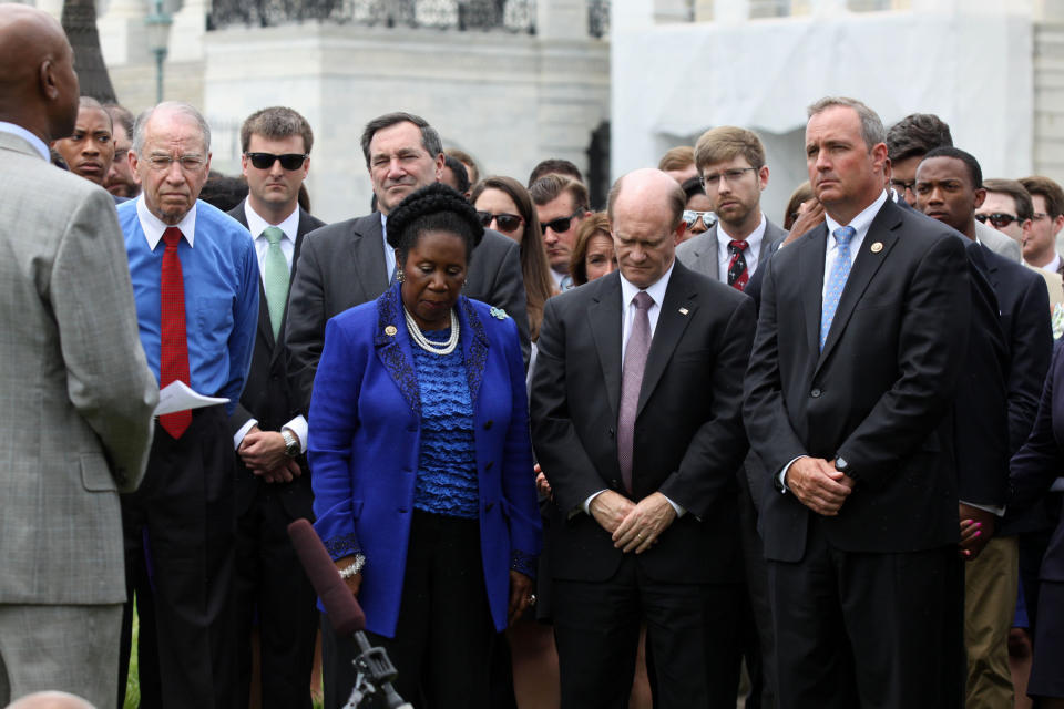 From left, Sen. Charles Grassley, R-Iowa, Sen. Joe Donnelly, D-Ind., Rep. Sheila Jackson Lee, D-Texas, Sen. Chris Coons, D-Del. Rep. Jeff Duncan, R-S.C., and others, participate in a prayer vigil on Capitol Hill in Washington, Thursday, June 18, 2015, as members of Congress and staff gathered in prayer to mourn the shooting victims of Emanuel AME Church in Charleston, SC. (AP Photo/Lauren Victoria Burke)