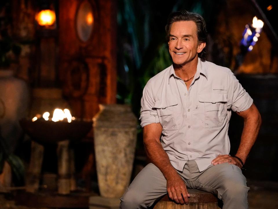 "Survivor" host Jeff Probst sitting at Tribal Council in front of fire-lit torches