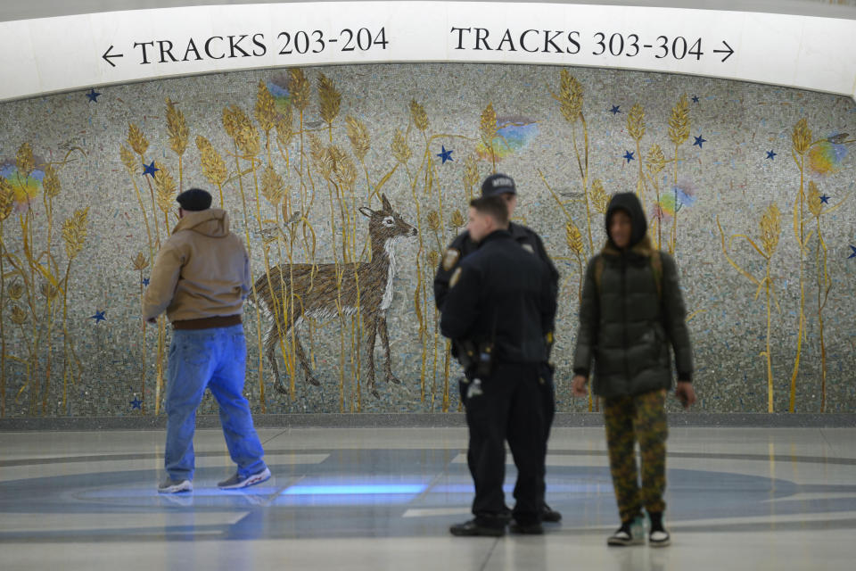 People walks past a mural in the new annex in Grand Central Station in New York, Wednesday, Jan. 25, 2023. After years of delays and massive cost overruns, one of the world's most expensive railway projects on Wednesday began shuttling its first passengers between Long Island to a new annex to New York City's iconic Grand Central Terminal (AP Photo/Seth Wenig)
