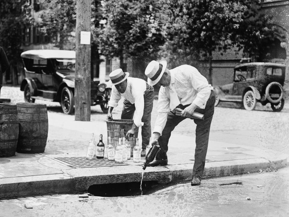 US federal agents pouring illegal alcohol out in 1921, in the midst of the Prohibition Era.
