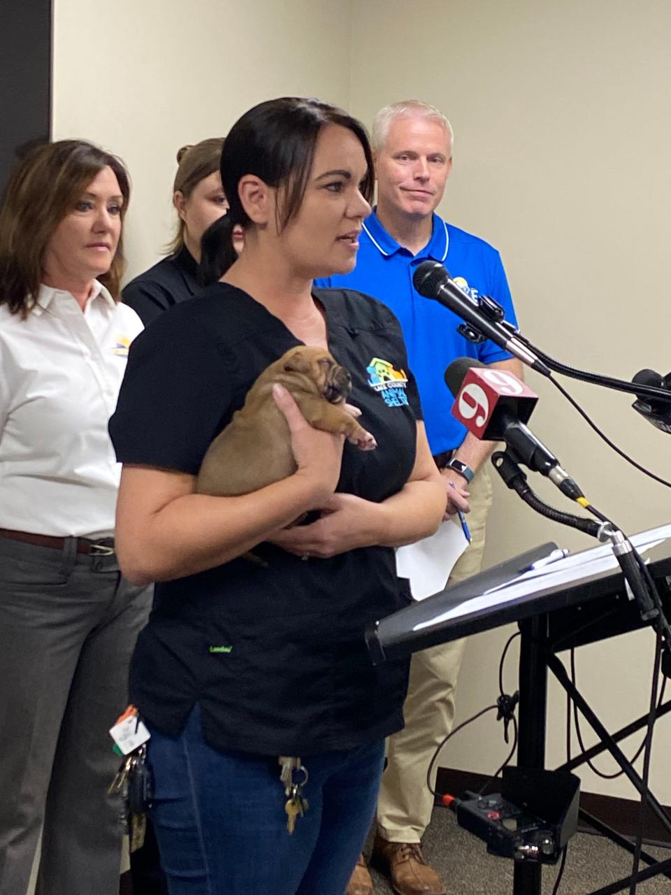 Whitney Boylston, director of Lake Animal Services, holds a puppy Wednesday at a storm preparation news conference to emphasize the need for pet owners to include their animals in hurricane plans.