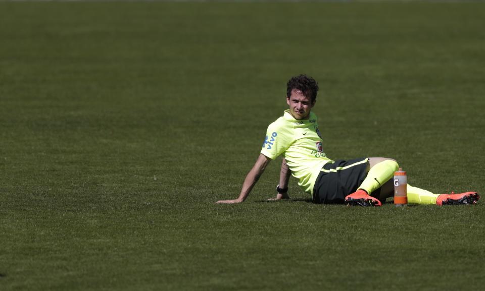 Brazil's national soccer team player Bernard sits on the pitch during a training session in Teresopolis