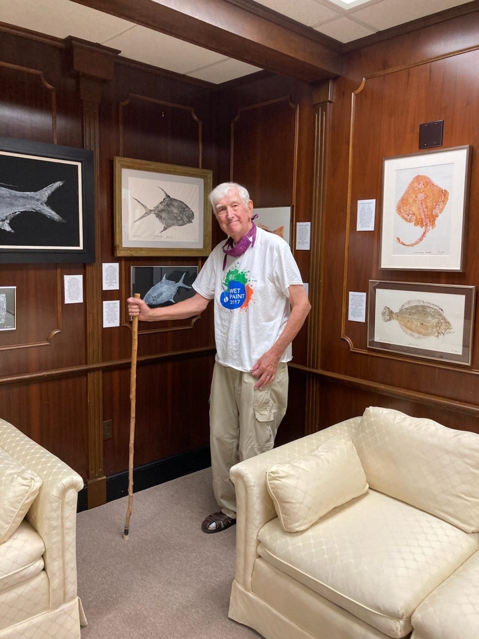 Middletown artist and angler Toney Chatowsky poses in front of his unique fish print artwork, made using a traditional Japanese technique.