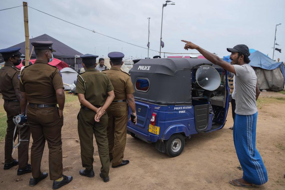 A protestor reacts to a police announcement aired using loudspeakers ordering protesters to vacate the site of months long anti government protests outside the president's office in Colombo, Sri Lanka, Thursday, Aug. 4, 2022. Sri Lanka's Parliament approved a state of emergency July 27. The decree gives the president the power to make regulations in the interest of public security and order. (AP Photo/Eranga Jayawardena)