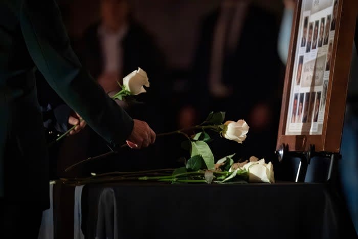 White roses, one for each victim, were laid by photographs of the victims.