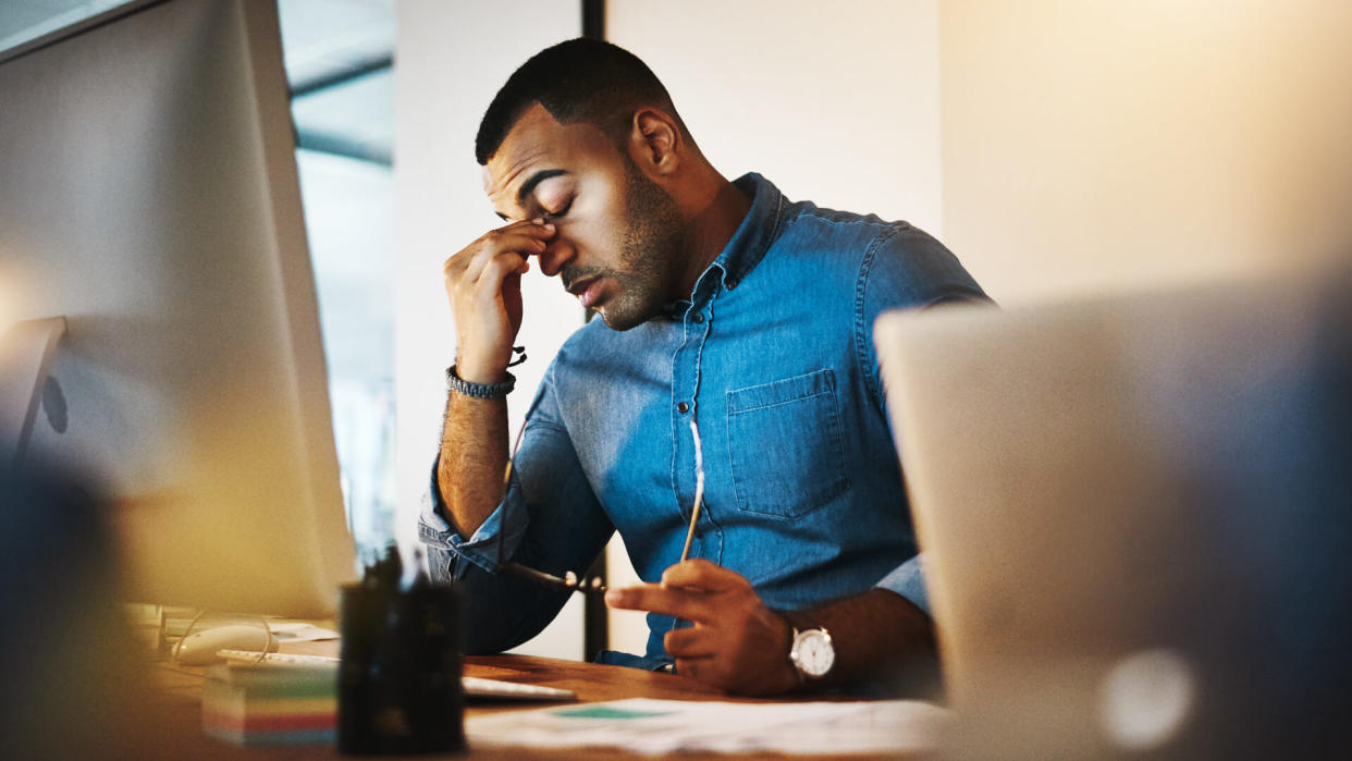 Shot of a young businessman experiencing stress during a late night at work.