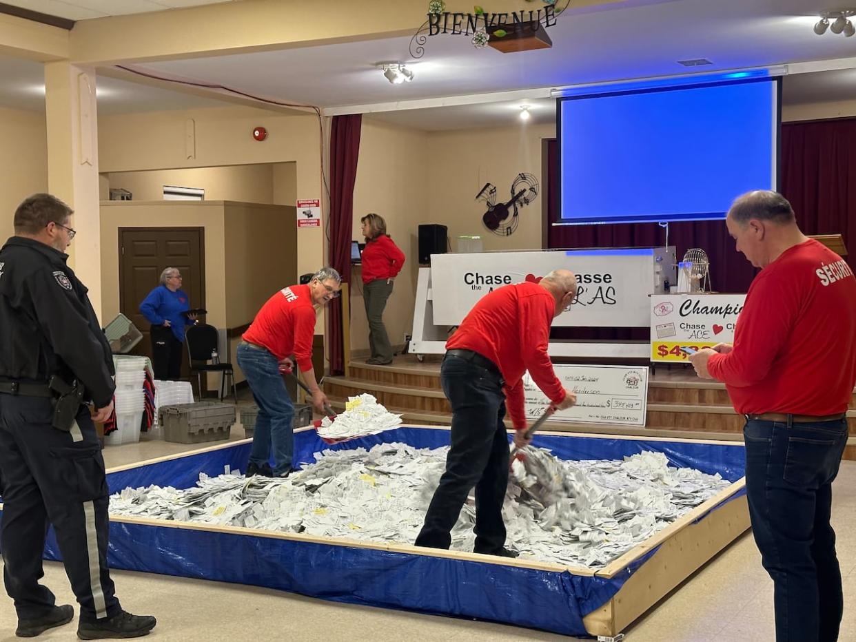 The Chase the Ace draw is broadcast live on Facebook each week, as security guards watch over the makeshift pool filled with tickets. (Nation Isaac/CBC - image credit)