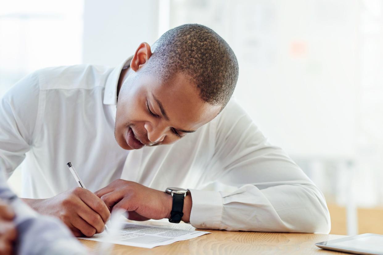 man reading and signing contract