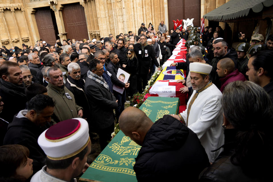 The four coffins of Turkish Cypriot students, victims of earthquake in Turkey, are covered with Turkish and Turkish Cypriot breakaway flags during a funeral procession in the Turkish occupied area in northeast coastal city of Famagusta, Cyprus, on Friday, Feb. 10, 2023. A funeral service was held in Famagusta city for Fahri Arkar, Mert Niyazi Topukcuoglu and brothers Doruk and Alp Akın, who perished in the ruins of their collapsed hotel in the Turkish city of Adiyaman. (AP Photo/Petros Karadjias)