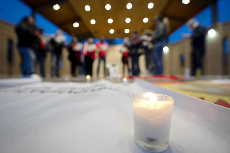 A candle burns as people gather for a Posada celebration, Sunday, Dec. 17, 2023, in Fort Morgan, Colo. Organizers put on the Posada, a Latin-American tradition based on the religious events of Joseph and Mary searching for shelter before the birth of Jesus, as a way for migrants in Colorado to feel a sense of unity during the holiday season. (AP Photo/Julio Cortez)