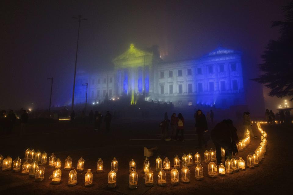 People light candles at midnight around the Legislative Palace on the 50th anniversary of the 1973 military coup, in Montevideo, Uruguay, Monday, June 26, 2023. (AP Photo/Matilde Campodonico)