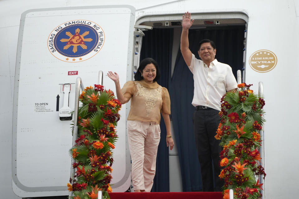 Philippine President Ferdinand Marcos Jr., right, waves beside wife Maria Louise as they board a plane for China on Tuesday, Jan. 3, 2023, at the Villamor Air Base in Manila, Philippines. (AP Photo/Aaron Favila)