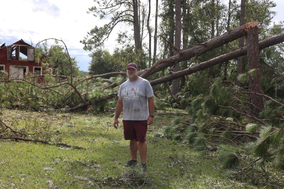 Price Harris, the Madison County High School football coach, stands in front of a barn he helped build as a child on his family's farmland in Madison, Florida on Wednesday, Aug. 30, 2023, the day Hurricane Idalia hit Florida's Gulf Coast.