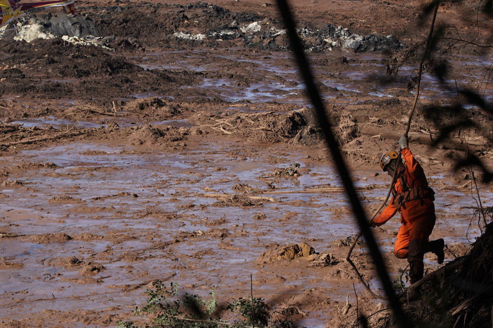 A firefighter looks for victims in the mud, days after a dam collapse in Brumadinho, Brazil, Monday, Jan. 28, 2019. Firefighters on Monday carefully moved over treacherous mud, sometimes walking, sometimes crawling, in search of survivors or bodies four days after a dam collapse that buried mine buildings and surrounding neighborhoods with iron ore waste. (AP Photo/Leo Correa)