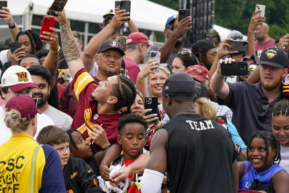 Washington Commanders wide receiver Terry McLaurin, center right, greets fans after an NFL football practice at the team's training facility, Thursday, July 27, 2023, in Ashburn, Va. (AP Photo/Alex Brandon)