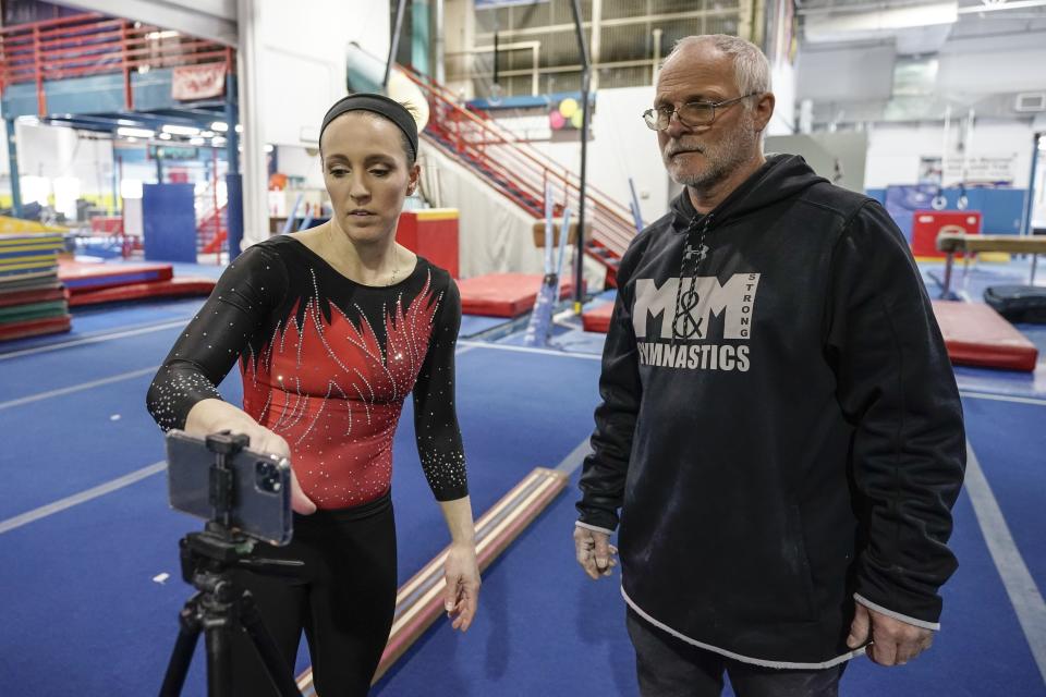 Former world champion and Olympic silver medalist Chellsie Memmel works out with her father and coach Andy Memmel Thursday, Feb. 18, 2021, in New Berlin, Wisc. Memmel, 32, is attempting a comeback. (AP Photo/Morry Gash)