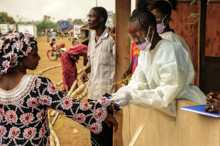 Sierra Leonean health officials check for the Ebola virus on passengers at a border crossing with Liberia in Jendema, on March 28, 2015