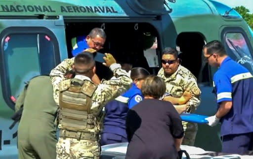 Paramedics carrying one of 15 people rescued from a religious sect in Panama's Veraguas province, close to an area where a mass grave containing seven bodies was found