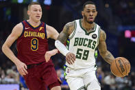 Milwaukee Bucks guard Rayjon Tucker drives on Cleveland Cavaliers guard Dylan Windler in the first half of an NBA basketball game, Sunday, April 10, 2022, in Cleveland. (AP Photo/David Dermer)