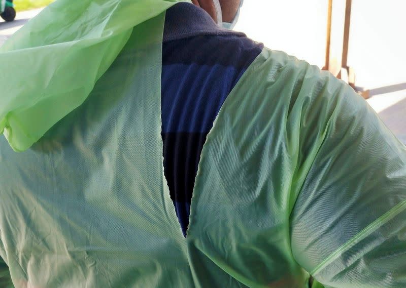 A doctor wearing a torn raincoat stands at the major coronavirus disease (COVID-19) treatment facility in Kolkata