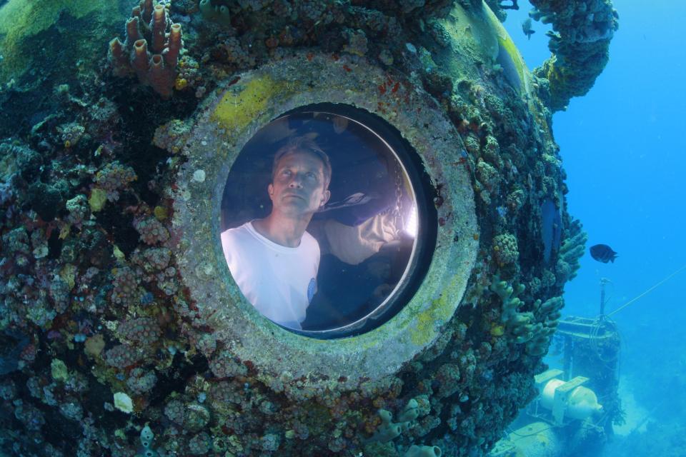 Fabien Cousteau is pictured inside the marine laboratory Aquarius in this undated handout photo obtained by Reuters July 2, 2014. Cousteau, grandson of famed French oceanographer Jacques Cousteau, emerged from the turquoise waters off the Florida Keys on July 2, 2014 morning, marking the end of a record-breaking, 31-day stay in an underwater habitat with a team of scientists and documentary filmmakers. The younger Cousteau, 46, along with two "aquanauts," took the 60-foot (18-meter) dive to Aquarius, a 43-foot-long (18-meter-long) laboratory resting off of Key Largo, on June 1 following years of preparation and delay. REUTERS/Kip Evans/Mission Blue/Handout via Reuters (UNITED STATES - Tags: SCIENCE TECHNOLOGY ANIMALS ENVIRONMENT) ATTENTION EDITORS - THIS PICTURE WAS PROVIDED BY A THIRD PARTY. REUTERS IS UNABLE TO INDEPENDENTLY VERIFY THE AUTHENTICITY, CONTENT, LOCATION OR DATE OF THIS IMAGE. FOR EDITORIAL USE ONLY. NOT FOR SALE FOR MARKETING OR ADVERTISING CAMPAIGNS. THIS PICTURE IS DISTRIBUTED EXACTLY AS RECEIVED BY REUTERS, AS A SERVICE TO CLIENTS. NO SALES. NO ARCHIVES. MANDATORY CREDIT