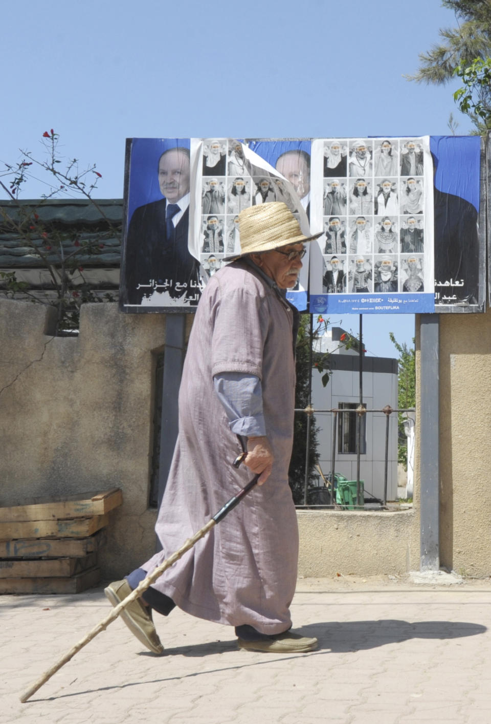 A man walks past electoral posters in Algiers, Wednesday, April 16, 2014. Algerians go to the polls Thursday to elect the president of their oil-rich country, a key U.S. ally in the fight against terror and a major natural gas provider to Europe. Six candidates are running for the presidency. President since 1999, Abdelaziz Bouteflika,77, is running for a 4th term despite being hit by a stroke last year that left him speaking and moving with difficulty. While he has not made a single campaign experience, he is expected to win with the full force of the state backing him. (AP Photo/Sidali Djarboub)