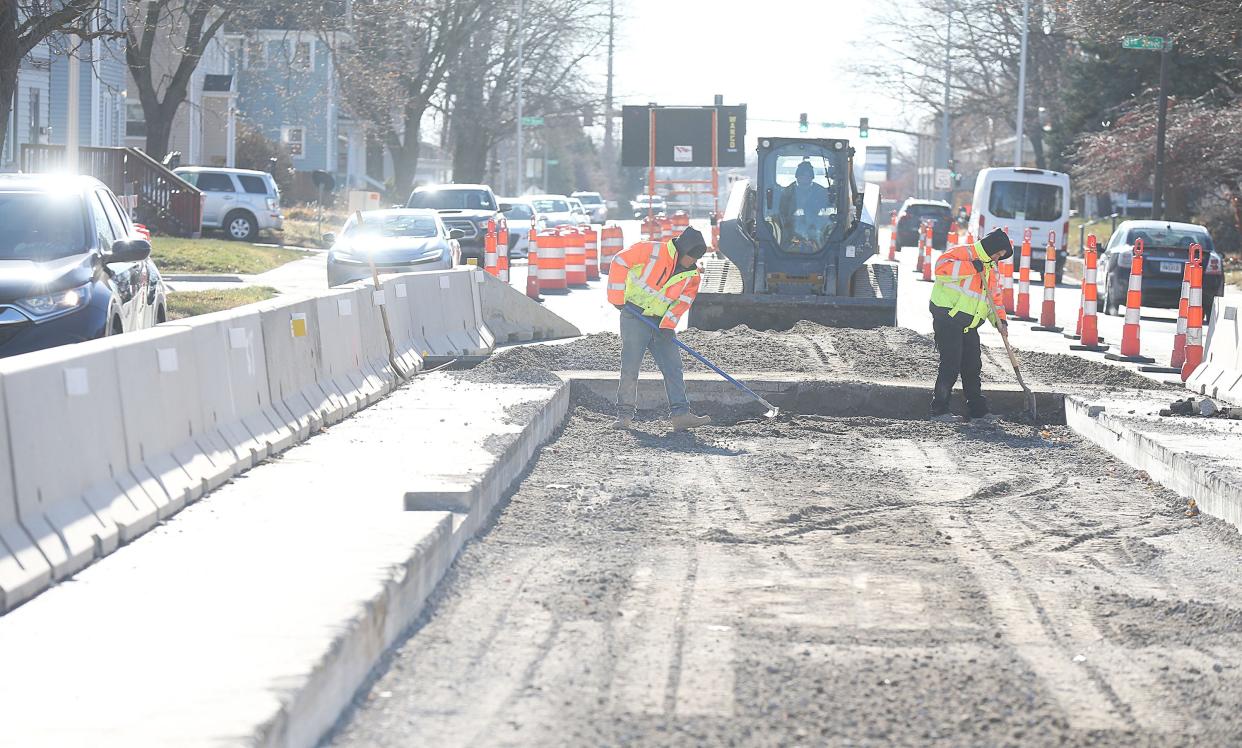 Construction workers fill up concrete on a sanitary sewer after finishing work on the Grand Ave on Monday, Dec. 18, 2023, in Ames, Iowa.