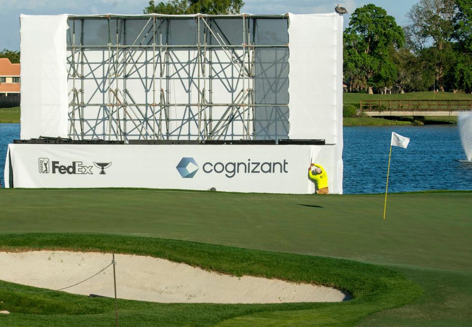 A worker fastens banners around the scoreboard that will be installed for the Cognizant Classic in the Palm Beaches at PGA National on February 21, 2024 in Palm Beach Gardens, Florida.