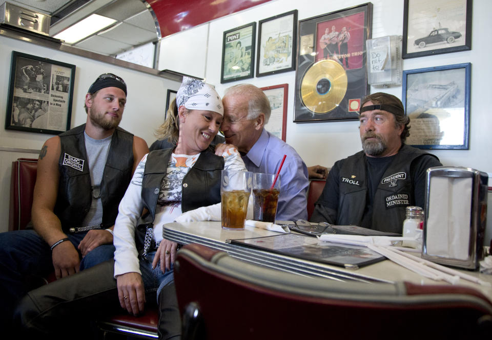 Then-Vice President Joe Biden talks to customers, including a woman who pulled up her chair in front of the bench Biden was sitting on, during a stop at Cruisers Diner in Seaman, Ohio, Sept. 9, 2012. (AP Photo/Carolyn Kaster, File)