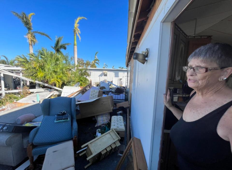 Fort Myers resident Sharon Popham assesses damage from Hurricane Ian at her mobile home on Friday morning.