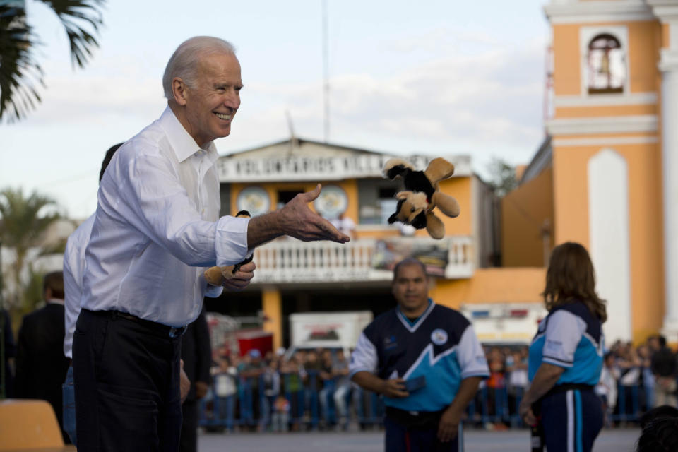 U.S. Vice President Joe Biden tosses a stuffed animal to children in Villa Nueva on the outskirts of Guatemala City, Tuesday, March 3, 2015. Biden gave a toy to each child from a group who gave him a karate demonstration on the second day of his trip to meet with Central American leaders regarding immigration issues. (Moises Castillo/AP Photo)