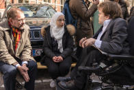 Faeza Satouf, center, talks with her lawyer, Niels-Erik Hansen, left, and a Danish member of Parliament at a meeting with Syrian refugees in Copenhagen, Denmark, Wednesday, April 21, 2021. Ten years after the start of the Syrian civil war, Denmark has become the first European country to start revoking the residency permits of some refugees from the Damascus area, including Satouf's. ​(AP Photo/David Keyton)