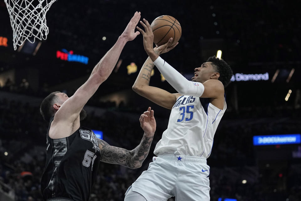 Dallas Mavericks forward Christian Wood (35) shoots over San Antonio Spurs forward Sandro Mamukelashvili (54) during the first half of an NBA basketball game in San Antonio, Wednesday, March 15, 2023. (AP Photo/Eric Gay)