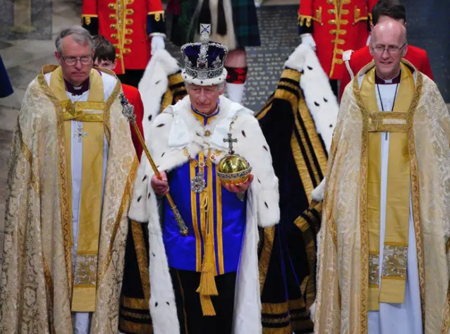 König Charles verlässt Westminster Abbey nach der Krönung, wobei er die kaiserliche Staatskrone und die Robe des Standes trägt. - Copyright: Ben Birchall - WPA Pool/Getty Images