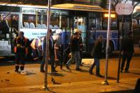 Investigators work near the wreckage of a bus at the scene of a suicide attack in Ankara on March 13, 2016