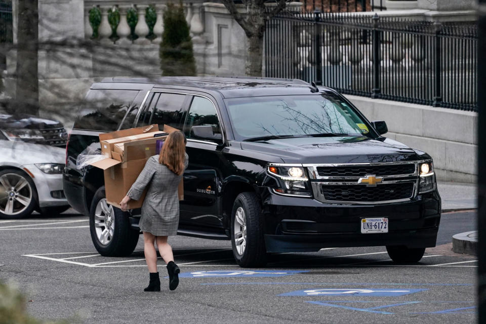 A woman carries boxes out of the White House's West Wing in Washington DC on January 15, 2021.