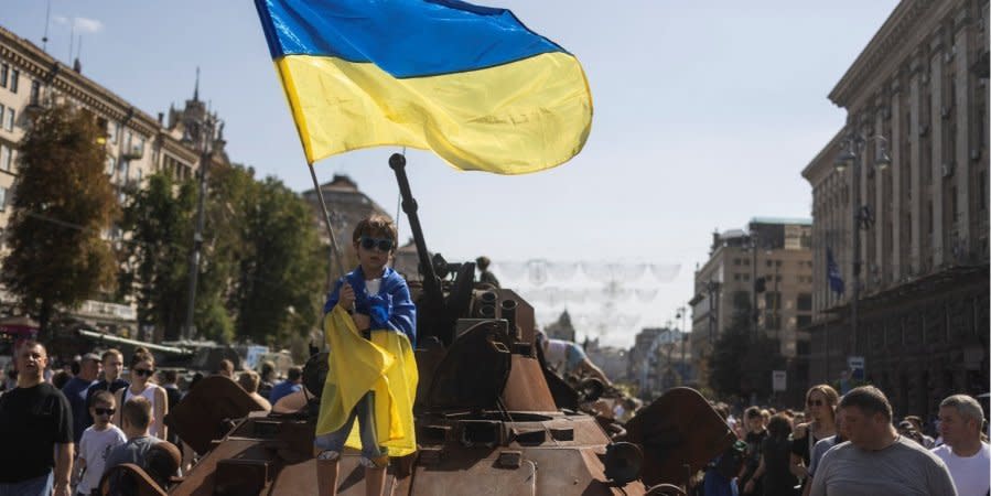 A boy with a flag of Ukraine on a destroyed Russian vehicle on Khreschatyk Street, Kyiv, August 21, 2022