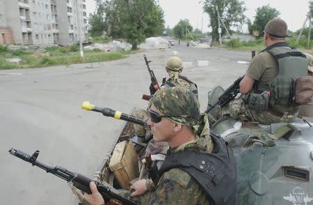 Members of the Ukrainian armed forces ride atop an armoured personnel carrier (APC) in the town of Avdiivka in Donetsk region, Ukraine, June 19, 2015. REUTERS/Maksim Levin