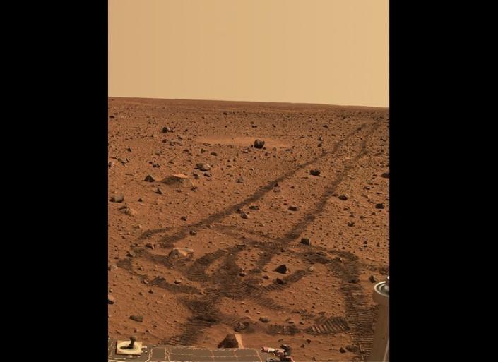 While driving over the reddish rocks and soils of Mars, the rover&#39;s wheels dig below the thin  dusty layer and reveal darker, brownish soils just below. The circular tracks are &quot;pirouettes&quot;  that the rovers occasionally do to align their radio antennas for best possible communications.    &lt;em&gt;Spirit rover, Pancam image, mission sol (martian day) 141 (May 26, 2004).  From &quot;Postcards from Mars&quot; by Jim Bell; Photo credit: NASA/JPL/Cornell University&lt;/em&gt;