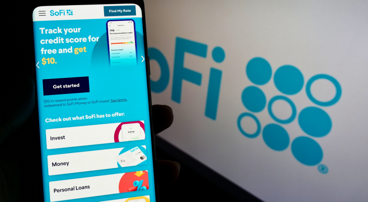 Person holding smartphone with website of US financial company Social Finance Inc (SoFi) on screen with logo Focus on center of phone display
