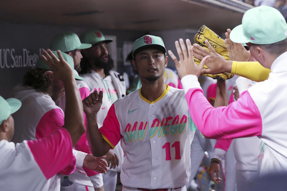 San Diego Padres' Yu Darvish (11) is congratulated by teammates in the dugout during the seventh inning of the team's baseball game against the Arizona Diamondbacks on Friday, July 15, 2022, in San Diego. (AP Photo/Derrick Tuskan)