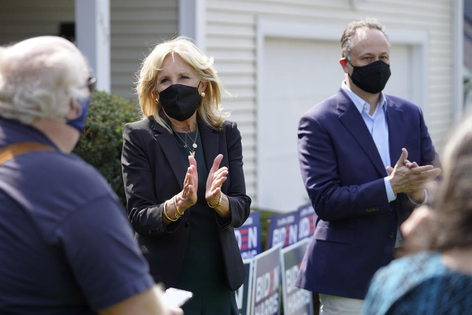 Jill Biden, center left, wife of Democratic presidential candidate former vice president Joe Biden, and Doug Emhoff, center right, husband of Democratic vice presidential candidate Sen. Kamala Harris, D-Calif., applaud while greeting supporters during a campaign stop, Wednesday, Sept. 16, 2020, in Manchester, N.H. (AP Photo/Steven Senne)