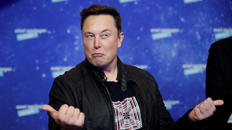 A photo of Elon Musk making a funny face with thumbs up symbols.