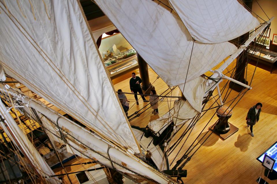Visitors to the New Bedford Whaling Museum are dwarfed by the half-scale replica of a whaling ship.