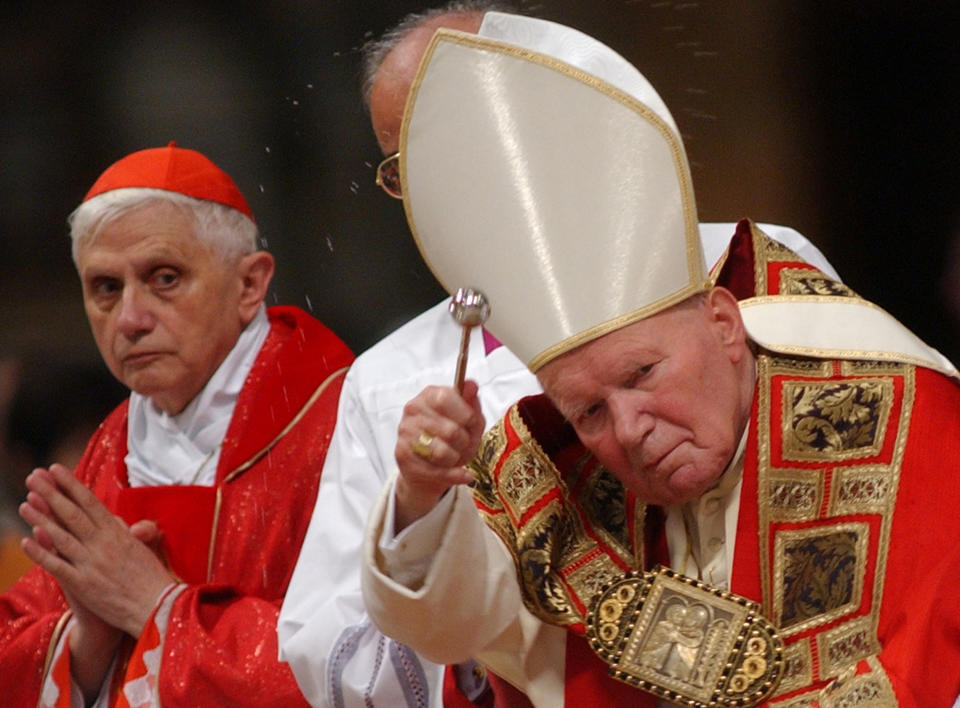 FILE - Cardinal Joseph Ratzinger of Germany, left, looks at Pope John Paul II during a Mass in St. Peter's Basilica at the Vatican on Sept. 11, 2002. As John Paul’s right-hand man on doctrinal matters, Ratzinger wrote documents reinforcing church teaching opposing homosexuality, abortion and euthanasia, and asserting that salvation can only be found in the Catholic Church. Pope Emeritus Benedict XVI, the German theologian who will be remembered as the first pope in 600 years to resign, has died, the Vatican announced Saturday Dec. 31, 2022. He was 95. (AP Photo/Pier Paolo Cito, File)