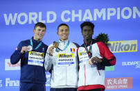 Silver medalist Maxime Grousset of France, left, gold medalist David Popovici of Romania, centre, bronze medalist Joshua Liendo Edwards of Canada, right, pose with their medals after the Men 100m Freestyle final at the 19th FINA World Championships in Budapest, Hungary, Wednesday, June 22, 2022. (AP Photo/Petr David Josek)